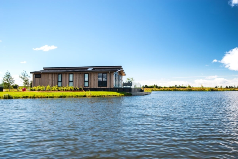 static caravan by the side of a lake with blue skies